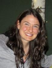 photo of Molly Strear smiling with long dark brown hair, white skin, light gray shirt and dark gray background