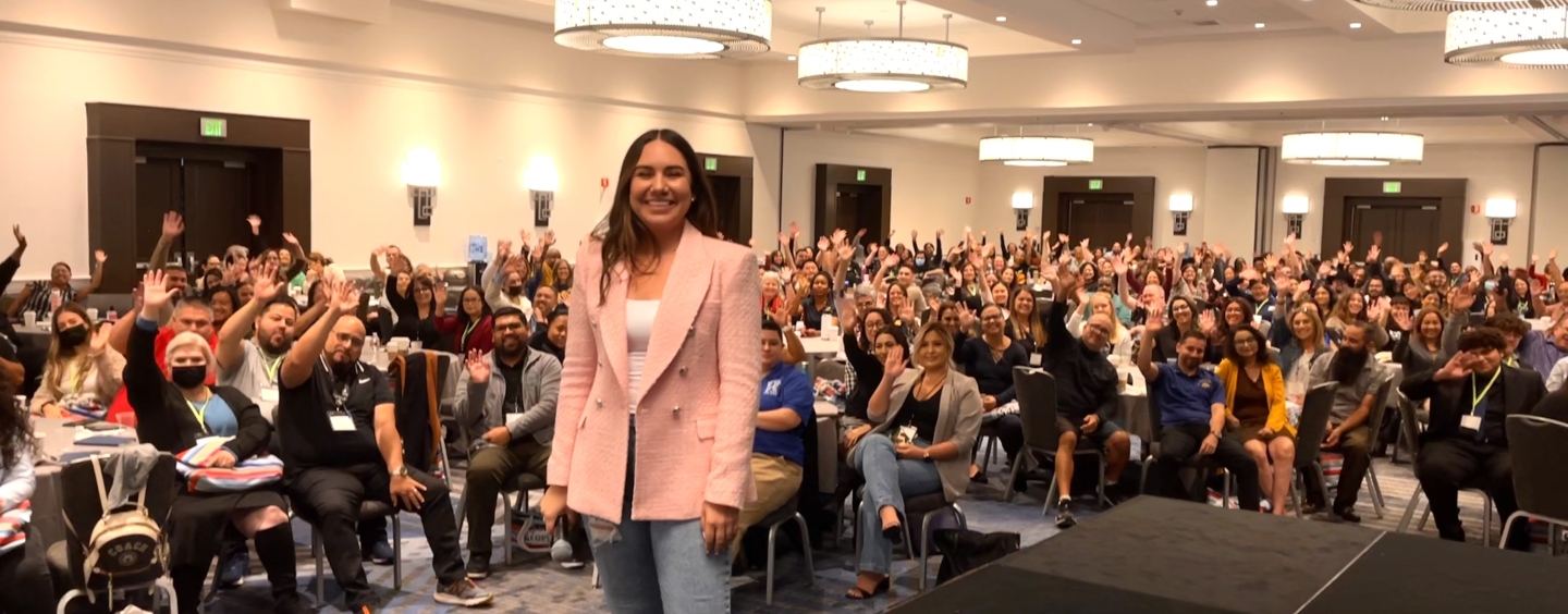 Iveth Lopez Obeso standing in a pink blazer in front of an audience