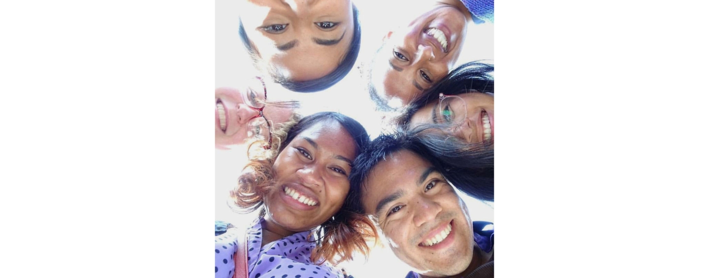 a group of students looking down and smiling