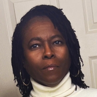photo of Marcia Miller, black braids, brown skin, white turtleneck