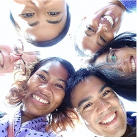 photo looking up at six smiling faces in a circle 