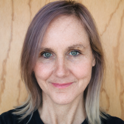Headshot of woman with white skin and ligh brown shoulder length hair smiling