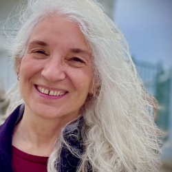 headshot of Rebecca Toporek, smiling with long white hair and white skin
