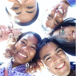 photo looking up at six smiling faces in a circle 